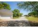 Long driveway leading to an attached two-car garage, with lush landscaping and trees at 160 Vinnys Way, Covington, GA 30014