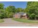 Charming exterior of a brick two-story home surrounded by mature trees and a well-manicured lawn at 160 Vinnys Way, Covington, GA 30014