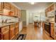 Bright kitchen with stainless steel appliances, wood cabinets, and hardwood floors leading to dining at 160 Vinnys Way, Covington, GA 30014