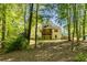 View of the rear of the house from a treed area showcasing its back porch at 160 Vinnys Way, Covington, GA 30014