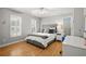 Well-lit bedroom featuring hardwood floors, white trim, and a gray padded headboard at 1860 Hill Chase, Alpharetta, GA 30022