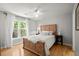 Bright bedroom with a wooden bed frame, hardwood floors, and a large window at 1860 Hill Chase, Alpharetta, GA 30022