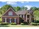 A classic brick home featuring a manicured lawn and lush landscaping, embodying suburban elegance at 1860 Hill Chase, Alpharetta, GA 30022
