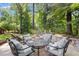 Backyard patio area with cushioned seating surrounded by green trees and landscaping at 1860 Hill Chase, Alpharetta, GA 30022