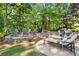 Backyard patio featuring stone walls, lounge chairs, sitting area, and lush landscaping at 1860 Hill Chase, Alpharetta, GA 30022