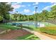 A view of well-maintained tennis courts with trees in the background and benches for relaxing at 1860 Hill Chase, Alpharetta, GA 30022