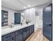 Modern bathroom featuring a blue vanity with a white countertop, a large mirror, and wood-look flooring at 2921 Country Squire Ln, Decatur, GA 30033