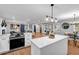 Modern kitchen with white cabinets, stainless steel appliances, and an island open to the dining and living areas at 2921 Country Squire Ln, Decatur, GA 30033