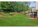 Expansive backyard with lush green lawn, mature trees, and a deck area, ideal for outdoor activities and gatherings at 927 Ivey Chase Pl, Dacula, GA 30019