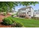 Spacious backyard with lush landscaping, wooden deck, and stairs leading to a well-maintained lawn at 927 Ivey Chase Pl, Dacula, GA 30019