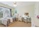 Bright bedroom with a ceiling fan and large window, complete with a comfortable bed and a functional desk area at 927 Ivey Chase Pl, Dacula, GA 30019