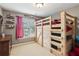 Cozy bedroom featuring a wooden bunk bed, window with natural light, and decorative shelving at 927 Ivey Chase Pl, Dacula, GA 30019