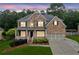 Charming two-story brick home with a welcoming front porch, manicured lawn, and well-lit windows at 927 Ivey Chase Pl, Dacula, GA 30019