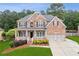 Charming brick two-story home with a welcoming front porch and a well-manicured lawn at 927 Ivey Chase Pl, Dacula, GA 30019