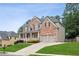 Beautiful two-story home with a front porch, brick facade, and lush green lawn at 927 Ivey Chase Pl, Dacula, GA 30019