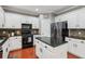 Modern kitchen with white cabinets, center island, black countertops and stainless steel appliances at 927 Ivey Chase Pl, Dacula, GA 30019