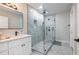 Stylish bathroom with a glass shower, stone floors, and a white vanity with black hardware at 240 Patterson Se Ave, Atlanta, GA 30316