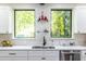 Bright kitchen featuring stainless steel sink, white cabinets, and views of lush greenery at 240 Patterson Se Ave, Atlanta, GA 30316