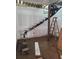 Unfinished black metal staircase under construction with bare wall, beam ceiling and standing ladder at 240 Patterson Se Ave, Atlanta, GA 30316