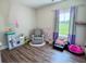 Bright bedroom with wood floors, glider chair, and natural light at 2980 Hd Atha Rd, Covington, GA 30014