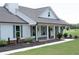 Lovely single-story home featuring a welcoming covered porch, complemented by landscaped garden beds and gray shutters at 2980 Hd Atha Rd, Covington, GA 30014