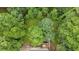 Aerial view of a property nestled among mature trees, featuring a deck and driveway at 40 Picketts Forge W Dr, Acworth, GA 30101