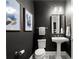 Stylish half bathroom with a pedestal sink, framed mirror, and decorative artwork over the toilet at 4137 Avid Park, Marietta, GA 30062