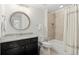 Well-lit bathroom featuring a granite vanity, round mirror, and shower-tub combination with a tiled wall at 4137 Avid Park, Marietta, GA 30062