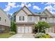 Charming two-story townhome featuring a brick facade, two-car garage, and beautifully landscaped front yard at 4137 Avid Park, Marietta, GA 30062