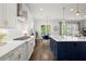 Spacious kitchen with white cabinets, dark island, stainless appliances, and a view to dining area at 4137 Avid Park, Marietta, GA 30062