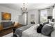 Bright main bedroom with hardwood floors, shutters, chandelier and decorative artwork over cabinet at 4137 Avid Park, Marietta, GA 30062