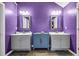 Modern bathroom featuring dual vanities, contemporary mirrors, fixtures, and a striking purple color scheme at 5115 Estonian Dr, Fairburn, GA 30213