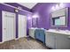 Bathroom with double sink vanity, and generous counter space, featuring bright purple walls at 5115 Estonian Dr, Fairburn, GA 30213