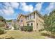 View of a two-story home showing a stone exterior, dark shutters, and a well-maintained lawn at 5115 Estonian Dr, Fairburn, GA 30213