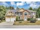 Inviting two-story home featuring stone accents, a two-car garage, and well-manicured landscaping at 5115 Estonian Dr, Fairburn, GA 30213