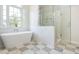Bright bathroom featuring a freestanding tub under an arched window and a glass-enclosed shower with marble surround at 1096 Bridge Mill Ave, Canton, GA 30114