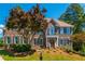 Stately two-story brick home with lush landscaping, beautiful lawn, and a charming, covered front porch at 1096 Bridge Mill Ave, Canton, GA 30114