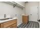 Functional laundry room with a sink, storage cabinet, and stylish tile flooring at 1096 Bridge Mill Ave, Canton, GA 30114