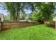 A fenced yard with a lush green lawn and mature landscaping offers privacy at 215 Truehedge Trce, Roswell, GA 30076