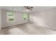Spacious bedroom featuring neutral carpeting, a ceiling fan, and two bright windows at 215 Truehedge Trce, Roswell, GA 30076