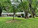 Single-story home with attached garage and beautiful lawn surrounded by mature trees at 215 Truehedge Trce, Roswell, GA 30076
