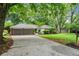 Charming brick home with a two-car garage and a lush, green lawn surrounded by mature trees at 215 Truehedge Trce, Roswell, GA 30076