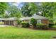 Charming brick home with a well-manicured lawn, mature trees, and a two-car garage at 215 Truehedge Trce, Roswell, GA 30076