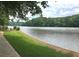 Scenic lake view featuring lush green grass and the edge of a sidewalk, perfect for lakeside strolls at 215 Truehedge Trce, Roswell, GA 30076