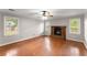 Cozy living room with hardwood flooring, a brick fireplace, and bright windows at 215 Truehedge Trce, Roswell, GA 30076