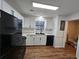 Bright kitchen featuring white cabinets, sleek black appliances, and durable floors at 6002 Pat Mell Se Pl, Smyrna, GA 30080