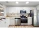Well lit kitchen featuring stainless steel appliances, white cabinetry, and wood grain flooring at 607 Riverview Se Dr # 607, Marietta, GA 30067