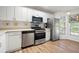 Bright kitchen featuring stainless steel appliances, white cabinetry, and wood grain flooring at 607 Riverview Se Dr # 607, Marietta, GA 30067