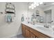 Bright bathroom with a double sink vanity, decorative shelving, and a large mirror at 663 Serramonte Dr, Marietta, GA 30068