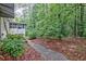 View of home's backyard with mature trees, covered structure, landscaping and walkway at 1774 Willis Mill Rd, Atlanta, GA 30311